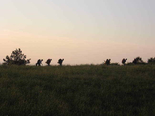Hikers appear on the horizon, coming from the South
