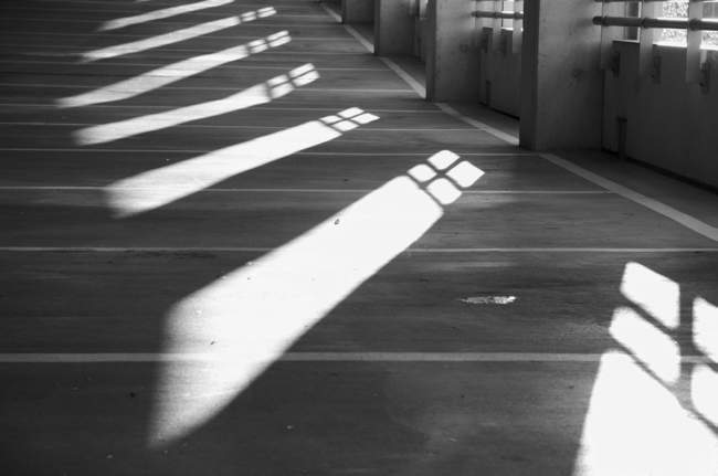 The morning light creates a pattern on the floor of the parking garage