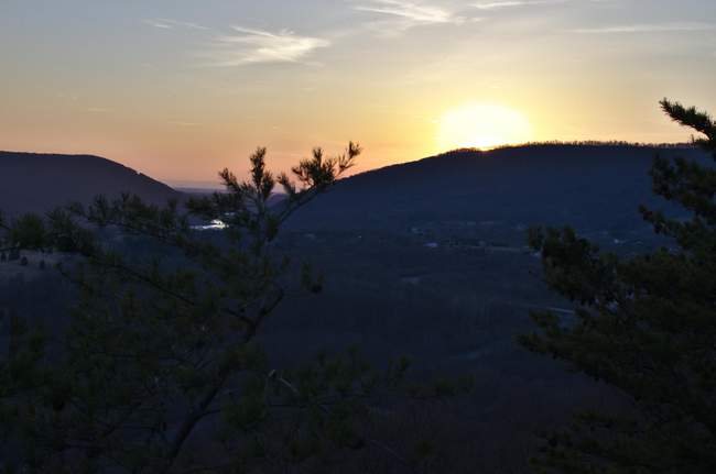 The sun dips just below the mountaintop.