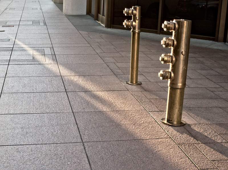 The light streaks down the sidewalk at 6:30 AM